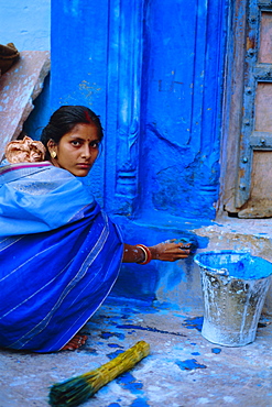 Woman painting her house, Jodhpur, Rajasthan, India