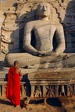 Monk in front of the seated Buddha statue, Gol Vihara, Polonnaruwa, Sri Lanka, Asia