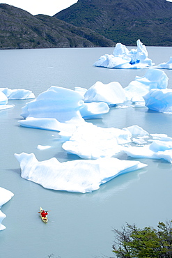 Person kayaking between floating icebergs, Lago Gray (Lake Gray), Torres del Paine National Park, Patagonian Andes, Patagonia, Chile, South America