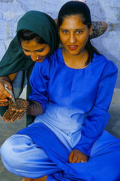 Portrait of two young women applying henna to hand, Jaisalmer, Rajasthan state, India, Asia