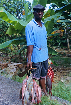 Portrait of a fisherman and his catch, near to Anse Possession, island of Praslin, Seychelles, Indian Ocean, Africa