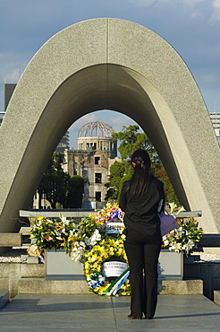 Girl praying at cenotaph, A Bomb Dome, Peace Park, Hiroshima city, Western Japan, Asia