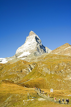 Line of hikers walking on trail near the Matterhorn, 4477m, Zermatt Alpine Resort, Valais, Switzerland, Europe 