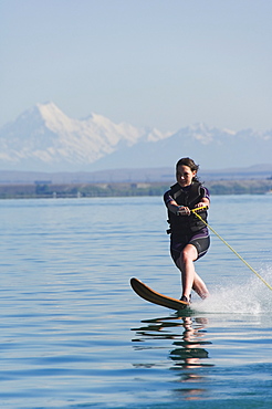 Water skier on Lake Benmore and a distant Aoraki (Mount Cook), 3754m, Australasia's highest mountain, Mackenzie Country, Otago, South Island, New Zealand, Pacific