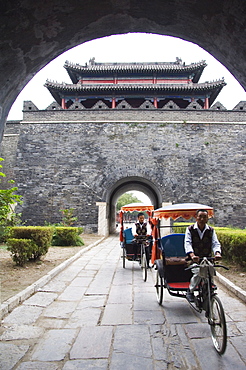 Tourist rickshaw at a city gate watch tower, Qufu City UNESCO World Heritage Site, Shandong Province, China, Asia