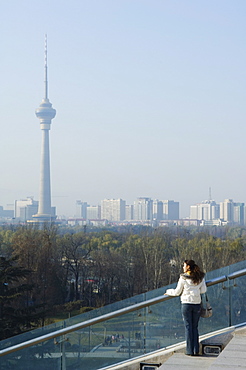 A Chinese girl in front of The CCTV Tower (China Central Television), Beijing, China, Asia