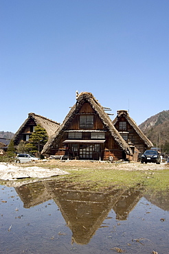 Snow melt, reflection of gasshou zukuri thatched roof houses, Shirokawago, Ogimachi, Gifu prefecture, Honshu island, Japan, Asia