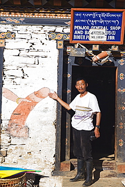 Man showing a phallic painting on a shop wall, Bhutan, Asia