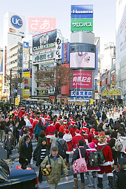 Christmas Santas walking across Shibuya crossing, Shibuya ward, Tokyo, Japan, Asia