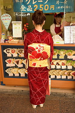 Girl in kimono, yukata buying crepe, Kyoto city, Honshu, Japan, Asia