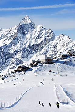 Skiers skiing on a ski run, mountain scenery in Cervinia ski resort, Cervinia, Valle d'Aosta, Italian Alps, Italy, Europe