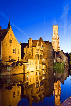 Reflection in canal of Belfort (belfry tower) illuminated at night, Old Town, UNESCO World Heritage Site, Bruges, Flanders, Belgium, Europe