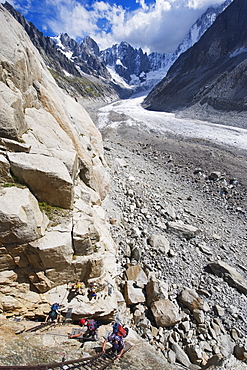 Climbers on a ladder on a rock face above Mer de Glace, Mont Blanc range, Chamonix, French Alps, France, Europe