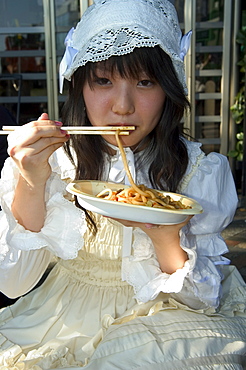 Tokyo subculture, teenage girl eating noodles, Harajuku, Yoyogi koen park, Tokyo, Honshu, Japan, Asia