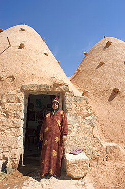 Local woman in front of her beehive house built of brick and mud, Srouj village, Syria, Middle East