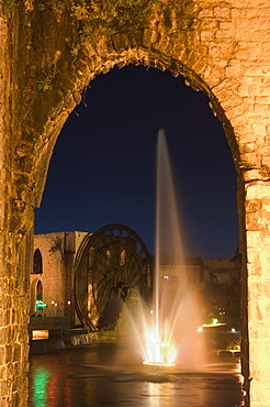 Fountain and water wheel on the Orontes River at night, Hama, Syria, Middle East