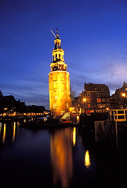 Floodlit tower at twilight reflected in the canal, Oudeschams, Amsterdam, The Netherlands (Holland), Europe