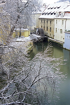 Snow-covered Certovka Canal and water wheel at Kampa Island, Mala Strana suburb, Prague, Czech Republic, Europe