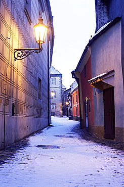 Snow covered 16th century cottages on Golden Lane (Zlata ulicka) in winter twilight, Hradcany, Prague, Czech Republic, Europe