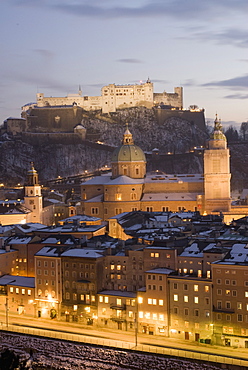 Old Town with towers of Glockenspiel, Dom and Franziskanerkirche churches dominated by the fortress of Festung Hohensalzburg at twilight, Salzburg, Austria, Europe