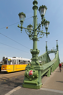 Tram and cyclist on Independence Bridge spanning Danube River, Budapest, Hungary, Europe