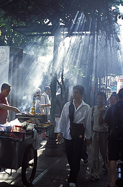 Street vendors selling grilled meat to passers-by on train platform, Bangkok, Southeast Asia, Thailand, Asia