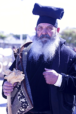 Man wearing the traditional Berritta Sardinian hat and carring the traditional double Sardinian sac, St. Antioco celebrations, Sant'Antioco,Sardinia, Italy, Europe