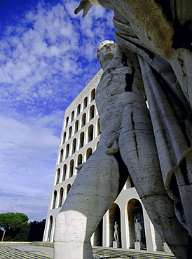 Statue with the Palazzo della Civilta di Lavoro behind, EUR (Esposizione Universale Romana), suburb planned in the 1930s during the time of Mussolini, Rome, Lazio, Italy, Europe