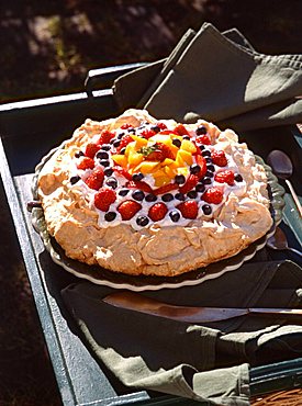 Meringue pie with strawberries, bilberries and cream, Italy