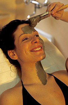 Woman takes a mud bath treatment, Rapolano, Tuscany, Italy