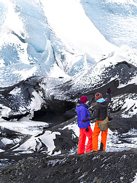 Glacier Solheimajoekull in the south of Iceland, a outlet glacier of glacie  Myrdalsjoekull. Two tourists watching the glacier. europe, northern europe, scandinavia, iceland,  February