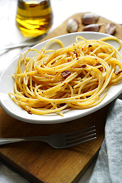 Traditional italian recipe, spaghetti pasta aglio, olio e peperocino, garlic, olive oil and chili, Italy, Europe