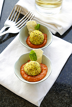 Fresh ricotta covered with chopped pistachios on an organic tomato cream