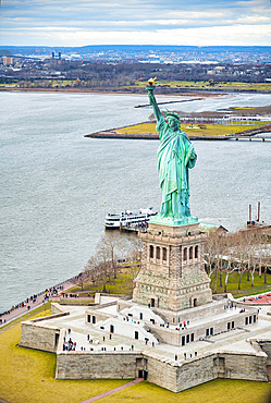 Statue of Liberty on Liberty Island and Ferry Boat with tourists, New York City.