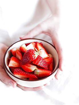 Fresh strawberries in a cup held by the gentle hands of a woman, Italy, Europe