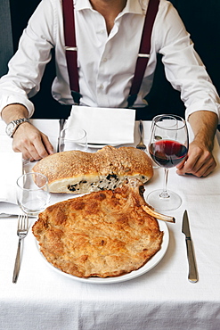 Cotoletta Milanese typically called "Orecchia di elefante" (Elephant ear) served with home made olive brad and a glass of red wine, Milan, Italy, Europe, Lombardy