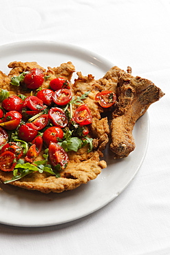 Cotoletta Milanese cooked by Restaurant Da Martino in Milan garnished with fresh rucola and tomatoes salad, Lombardy, Italy, Europe