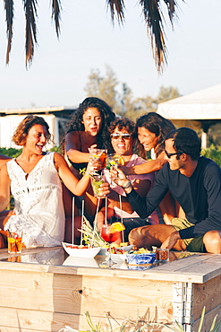 Girls and boys at sunset toast with an aperitif, EcoVillage Maremirtilli, Capaccio Paestum, Campania, Italy, Europe