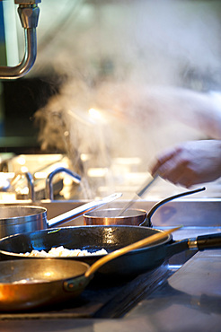 Hands of chefs at the stove; Italy