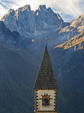 The church, in background the Focobon mountain range in the Pale di San Martino, part of the UNESCO world heritage Dolomites. Village Sappade, traditional alpine architecture in valley Val Biois . Europe, Central Europe, Italy