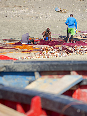 Fishermen are mending their colorful fishing nets on a beach near Sao Pedro. Island Sao Vicente, Cape Verde an archipelago in the equatorial, central Atlantic in Africa.