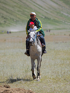 Visitor on horse. Folk and Sport festival on the Suusamyr plain commemorating Mr Koshomkul, a sportsman and folk hero of the last century. Asia, central asia, Kyrgyzstan