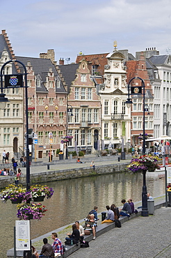 Students relaxing along the banks of the Graslei, Baroque style Flemish gables in the background, Ghent, Belgium, Europe