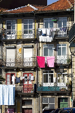 Flats in a residential street with traditional wrought iron balconies, washing hanging out in the sunshine, Oporto, Portugal, Europe