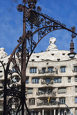 A wrought iron lamp frames La Pedrera (Casa Mila), an apartment block designed by Antonio Gaudi, UNESCO World Heritage Site, Passeig de Gracia, Barcelona, Catalunya, Spain, Europe 