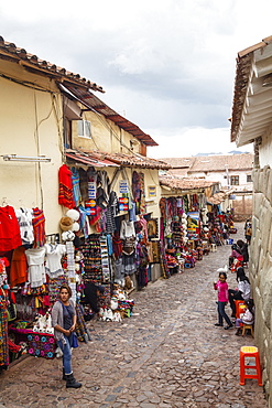 Shops along the the Inca wall at Hathunrumiyoq Street, las piedras del los 12 angulos (the stone of the 12 angles), Cuzco, Peru, South America