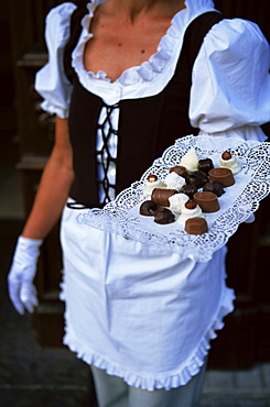 Waitress carrying tray of chocolate, Vilnius, Lithuania, Baltic States, Europe