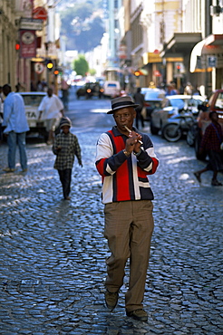 Man playing a flute while walking in the street in the city centre, Cape Town, South Africa, Africa