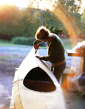 Boat builder working on a stich and glue kayak, Washington State, USA