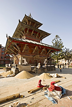 Piles of grain in front of the triple roofed pagoda of the Rato Machendranath temple, Patan, Kathmandu, Nepal, Asia